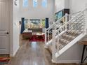 Bright entryway with hardwood floors leading into a living room with soaring ceilings and plentiful windows at 8354 Big Thompson St, Littleton, CO 80125