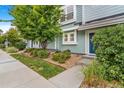 Inviting townhouse exterior with vibrant landscaping, a bright blue door, and a well-manicured lawn and walkway at 5895 Biscay St # D, Denver, CO 80249