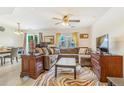 Cozy living room featuring a large sectional sofa, stylish rug, ceiling fan, and abundant natural light at 5895 Biscay St # D, Denver, CO 80249