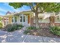 Attractive townhouse featuring brick accents, a covered entry, and mature trees at 2972 W Long Dr # C, Littleton, CO 80120