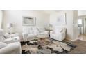 Bright living room with white couches and a large area rug at 5593 S Himalaya Way, Centennial, CO 80015