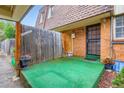 Cozy private patio area with green turf, brick accents, and a wooden fence at 1200 S Monaco St Pkwy # 31, Denver, CO 80224