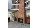 Bright living room featuring a brick fireplace, staircase, and hardwood floors at 9934 Grove St # C, Westminster, CO 80031