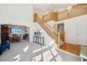 Bright and airy living room featuring an open staircase, high ceilings, and large windows for ample natural light at 16275 Electra St, Brighton, CO 80603