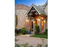 Detailed stone entrance with brick columns, decorative lighting, and well-manicured landscaping at 4 Redhawk Run, Englewood, CO 80113