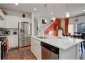 Modern kitchen featuring white cabinets, stainless steel appliances, and a large island with quartz countertops at 4754 N Joplin St, Denver, CO 80239