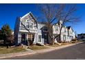 Street view of attractive townhouses, each with unique colors and designs, complemented by mature trees at 19803 Victorian Way, Parker, CO 80138