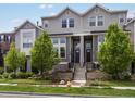 Charming townhome with gray siding, front steps and manicured landscaping at 5399 Valentia St, Denver, CO 80238