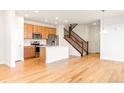 Open kitchen with stainless steel appliances, a kitchen island and hardwood floors at 23293 E Jamison Dr, Aurora, CO 80016
