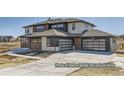 Modern glass garage doors and a wide driveway add curb appeal to this two story home's elevation at 9752 Canyon Wind Pt, Parker, CO 80138
