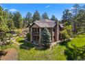 Picturesque home featuring multiple decks, a stone facade, and lush green landscaping at 10231 Democrat Rd, Parker, CO 80134