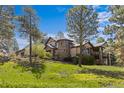 Sprawling two-story home featuring a stone turret, front lawn, lush greenery and professional landscaping at 10231 Democrat Rd, Parker, CO 80134