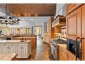 Spacious kitchen with custom cabinets, stone floors, brick ceiling, and stainless steel appliances at 10231 Democrat Rd, Parker, CO 80134