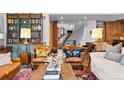 Cozy living room featuring leather armchairs, a bookshelf, and staircase in the background at 10231 Democrat Rd, Parker, CO 80134