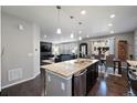 Open concept kitchen with granite island, stainless steel appliances and open view to living and dining areas at 10597 Casper St, Parker, CO 80134