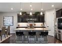 Modern kitchen with dark cabinets, granite countertops, and stainless steel appliances at 10597 Casper St, Parker, CO 80134