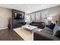 Cozy living room featuring a fireplace, large TV, neutral walls, and plenty of natural light at 10597 Casper St, Parker, CO 80134