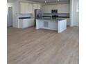 Bright, open-concept kitchen with an island, stainless steel appliances, and modern white cabinets at 6657 E 149Th Dr, Thornton, CO 80602