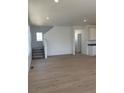 Spacious living area with wood floors, staircase, neutral paint, and recessed lighting at 6657 E 149Th Dr, Thornton, CO 80602