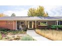 Charming home featuring a covered front porch, landscaped yard, and inviting walkway to the front door at 1800 S Niagara Way, Denver, CO 80224