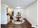 Dining area with a round table, four chairs, modern light fixture, and beautiful hardwood floors at 50 E Highline Cir # 101, Centennial, CO 80122