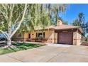 Lovely brick home with a well-kept lawn, garage, and a front porch, creating a welcoming curb appeal at 4960 S Fox St, Englewood, CO 80110