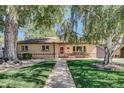 Charming single-story home featuring a well-manicured lawn, mature trees, and inviting front porch at 4960 S Fox St, Englewood, CO 80110