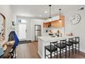 Modern kitchen with stainless steel appliances, white countertops, a breakfast bar, and stylish pendant lighting at 2120 N Downing St # 209, Denver, CO 80205