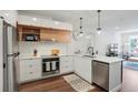Well-lit modern kitchen featuring stainless steel appliances, quartz countertops, and sleek cabinetry with hardwood floors at 2120 N Downing St # 209, Denver, CO 80205