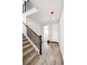 Inviting entryway with light wood floors, carpeted stairs, and a white front door at 1402 Rock Cliff Ave, Erie, CO 80516