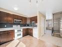 Traditional kitchen featuring tile flooring, granite counters, stainless microwave, and wooden cabinetry at 8901 Field St # 81, Broomfield, CO 80021
