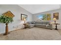 Bright living room features a plush gray sofa and ample natural light at 9662 Newcastle Dr, Highlands Ranch, CO 80130