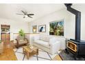 Bright living room featuring hardwood floors, a fireplace, and large windows overlooking the yard at 305 Jackson Ave, Firestone, CO 80520