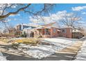 Brick ranch home with a covered porch and steps leading to the front entrance at 2895 Dexter St, Denver, CO 80207