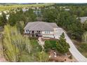 Spacious home surrounded by lush greenery, featuring a long driveway and a deck, creating a serene atmosphere at 20413 Bald Mountain Ct, Monument, CO 80132