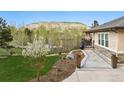 Landscaped yard with a charming flower tree and stone pathway leading to the house at 20413 Bald Mountain Ct, Monument, CO 80132