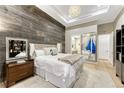 Cozy bedroom featuring a wood accent wall, mirrored closet, and tray ceiling with modern lighting at 7600 Landmark Way # 1514, Greenwood Village, CO 80111