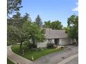 Aerial view of a well-kept home with an attached garage, mature trees, and green lawn at 13781 E Marina Dr # A, Aurora, CO 80014
