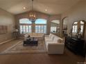 Bright living room featuring large windows, high ceilings, stylish light fixtures, and comfortable seating at 12380 Jasper Pointe Way, Castle Pines, CO 80108