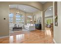 Bright living room with wood floors, large windows, vaulted ceilings, and elegant chandelier at 12380 Jasper Pointe Way, Castle Pines, CO 80108