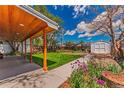 Covered patio overlooking expansive backyard with lush green lawn and storage shed at 2274 S Cherry St, Denver, CO 80222