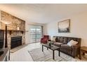 Inviting living room featuring a stone fireplace and sliding glass doors to a balcony at 8335 Fairmount Dr # 7-207, Denver, CO 80247