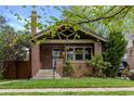 Charming brick bungalow with a cozy covered porch and well-manicured lawn at 2641 N Clayton St, Denver, CO 80205
