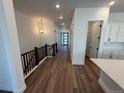 Spacious hallway with wood floors, modern lighting, and access to the kitchen and front door at 1111 Joseph Pl, Erie, CO 80026