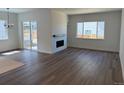 Bright living room featuring hardwood floors, fireplace, and sliding glass door to the backyard at 1111 Joseph Pl, Erie, CO 80026