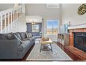 Open-concept living space features a brick fireplace, modern decor, and staircase at 9521 Joyce Ln, Highlands Ranch, CO 80126