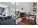 Bright living room featuring vaulted ceiling, brick fireplace, and stylish furniture at 9521 Joyce Ln, Highlands Ranch, CO 80126