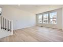 Bright living room with hardwood floors, white walls, and large windows offering natural light at 739 N Deer Park St, Watkins, CO 80137