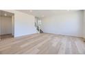Spacious living room featuring hardwood floors, white walls, a staircase, and bright natural light at 739 N Deer Park St, Watkins, CO 80137