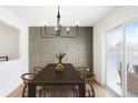 Well-lit dining area with a modern chandelier and sliding glass doors to the patio at 3643 S Mobile Way, Aurora, CO 80013